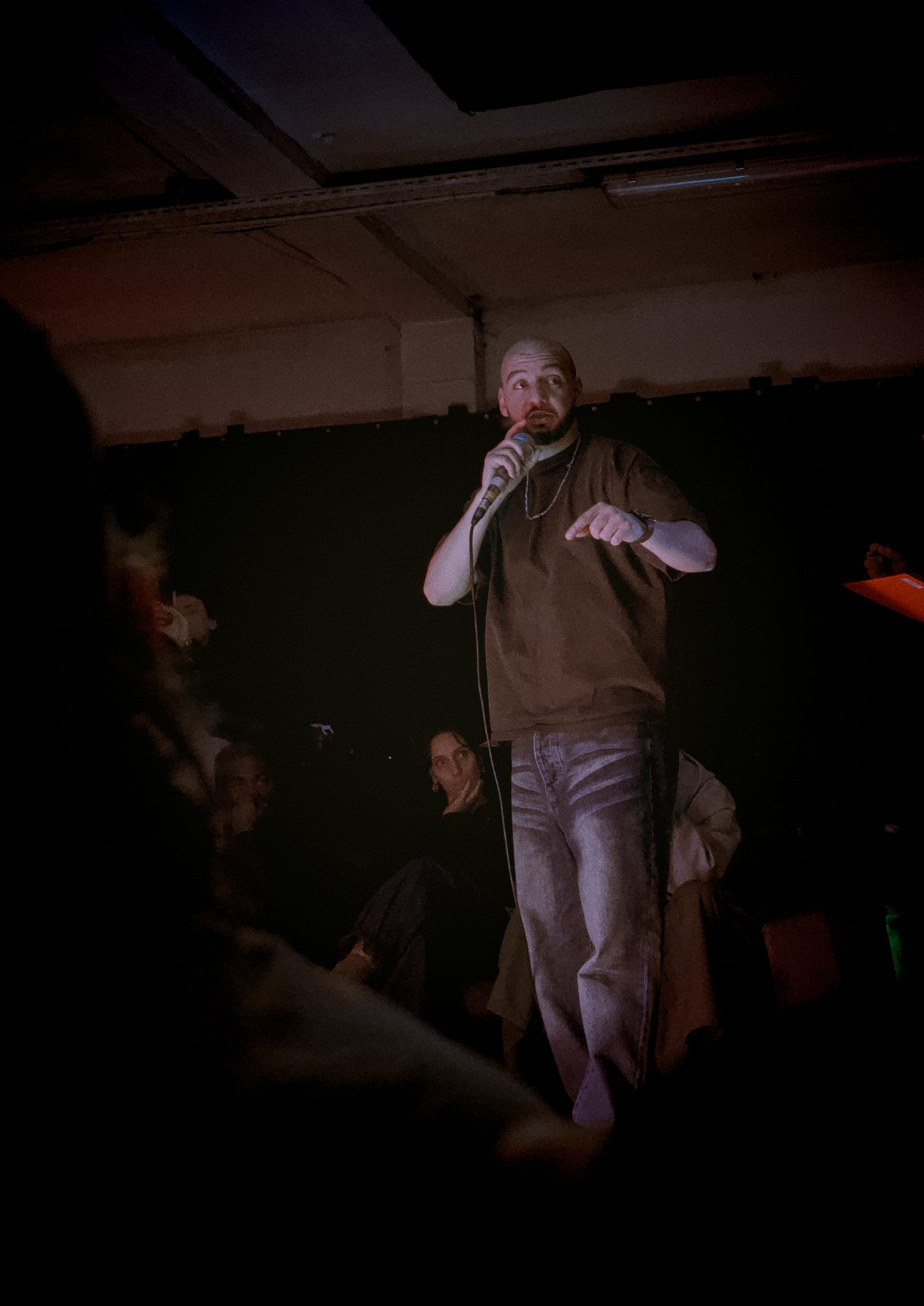 Youssef is holding the microphone and speaking to the audience.